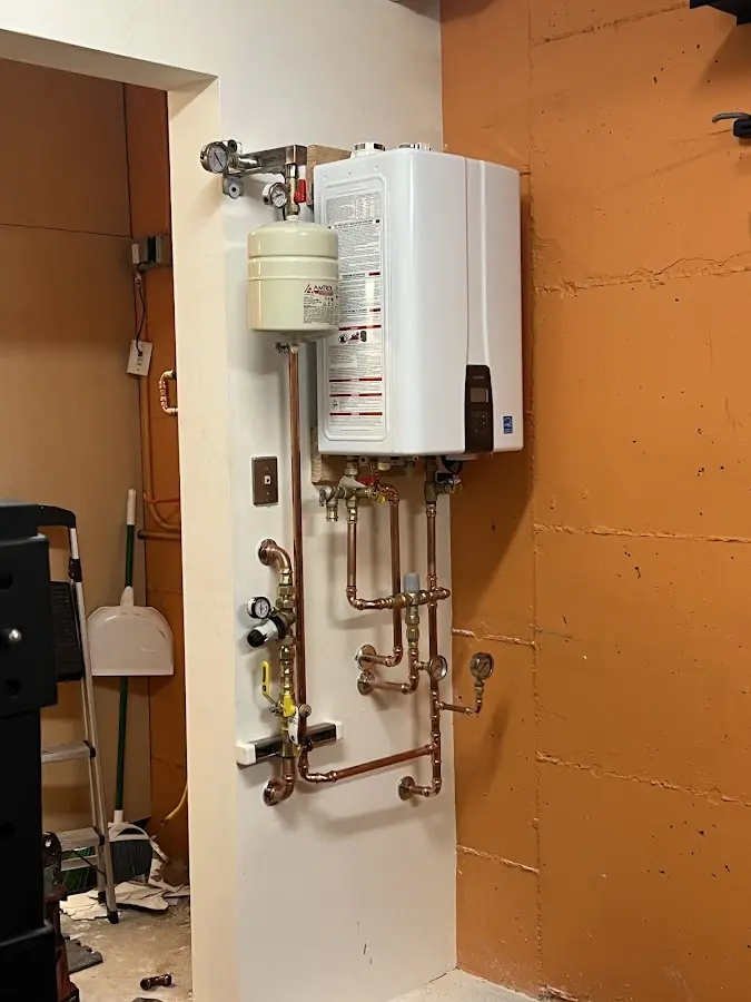 Plumbing technician inspecting water heater connections in San Jacinto